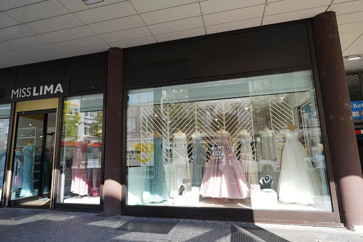 Ein rosa Satin-Kleid, das in einem Schaufenster ausgestellt ist.