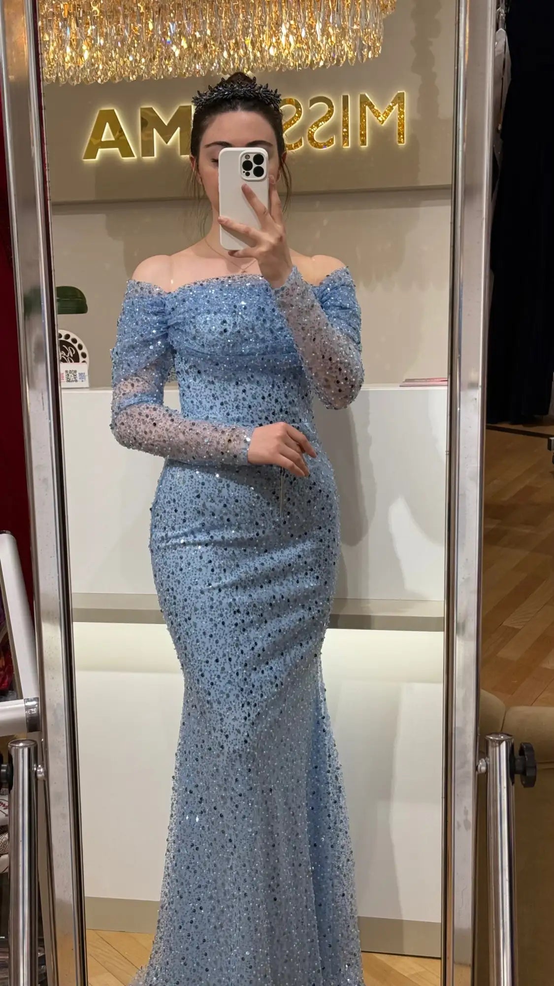 Ein schimmerndes hellblaues Meerjungfrau-Kleid, verziert mit funkelnden Pailletten und durchsichtigen langen Ärmeln.