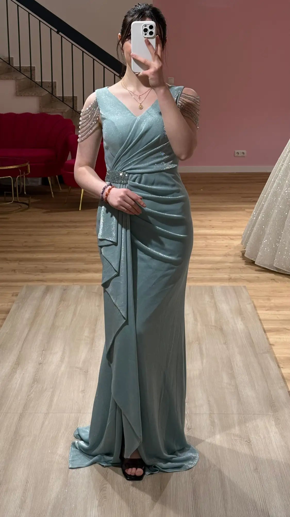 Ein schimmerndes hellblaues Satingown mit zarten Perlenakzenten an den Schultern und einer drapierten, taillierten Silhouette.